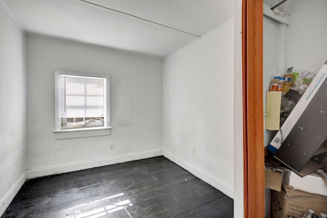 spare room with dark wood-type flooring and baseboards