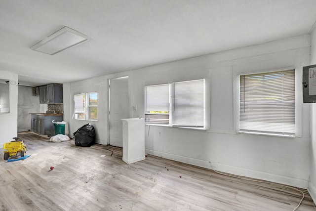 interior space with light wood finished floors, attic access, and baseboards