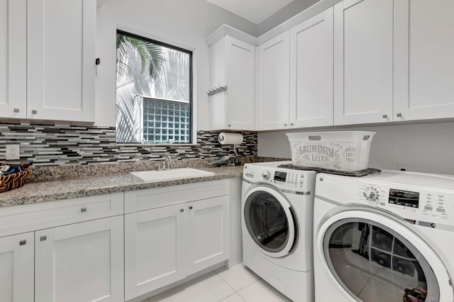 laundry area with cabinets, separate washer and dryer, light tile patterned flooring, and sink