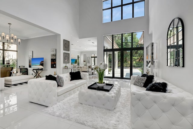 living room featuring light tile patterned flooring, a high ceiling, and a chandelier