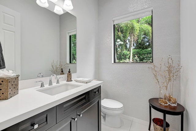 bathroom featuring toilet, vanity, and plenty of natural light