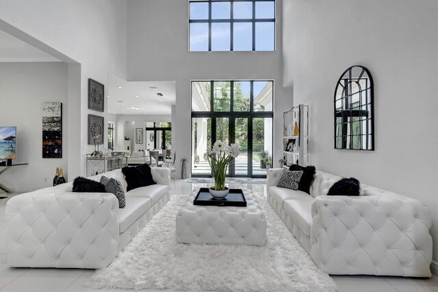 living room with light tile patterned floors, plenty of natural light, and a high ceiling