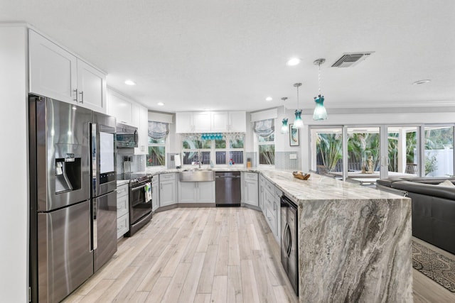 kitchen with stainless steel appliances, open floor plan, white cabinetry, and visible vents