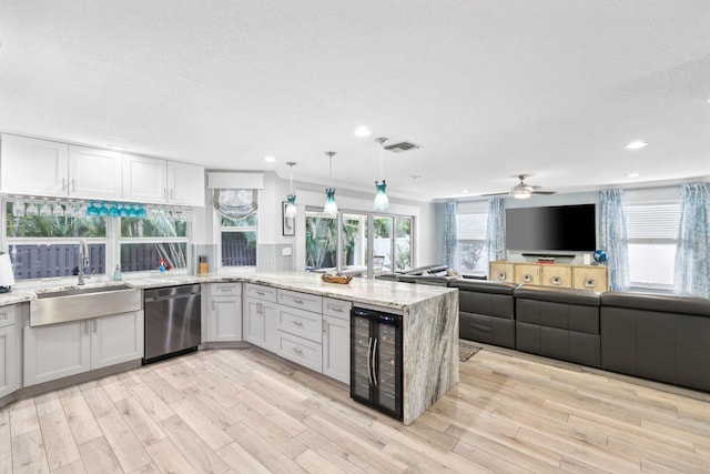 kitchen with wine cooler, white cabinetry, dishwasher, and a sink