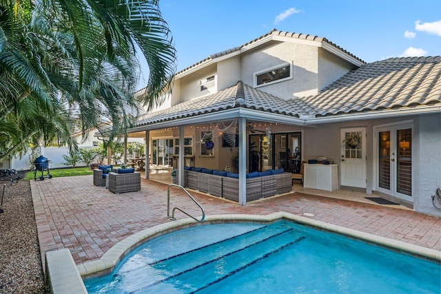 rear view of house featuring outdoor lounge area, a tile roof, fence, french doors, and stucco siding