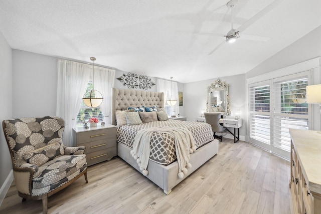 bedroom with lofted ceiling, a textured ceiling, baseboards, and light wood-style floors