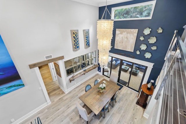 living area with light wood-type flooring, baseboards, visible vents, and a chandelier