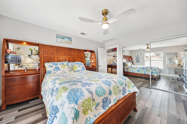 bedroom featuring attic access, visible vents, a ceiling fan, wood finished floors, and a textured ceiling