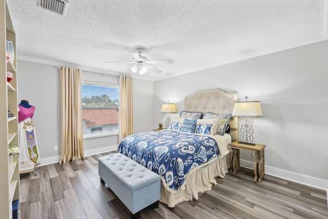 bedroom featuring a textured ceiling, wood finished floors, and visible vents