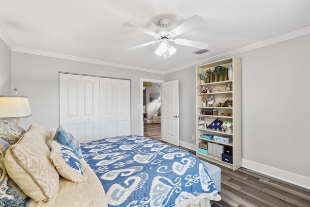 bedroom with visible vents, dark wood-style flooring, a closet, and ornamental molding