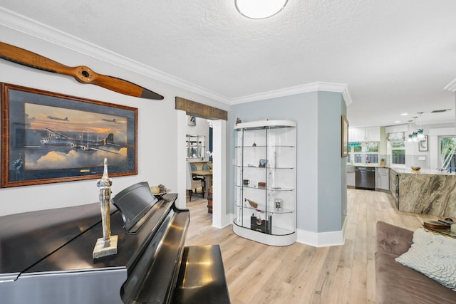 office with light wood finished floors, baseboards, ornamental molding, and a textured ceiling