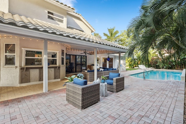 view of patio featuring an outdoor hangout area, exterior kitchen, a ceiling fan, and an outdoor pool