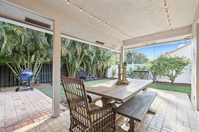 view of patio with outdoor dining space, area for grilling, and a fenced backyard