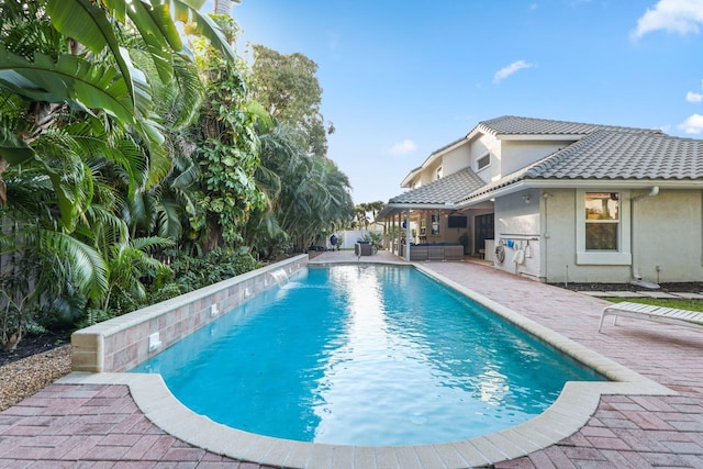 view of swimming pool with a patio, outdoor lounge area, and a fenced in pool