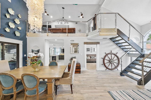 dining space featuring high vaulted ceiling, a wealth of natural light, visible vents, and light wood-style flooring