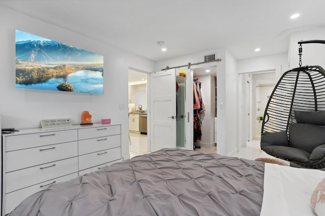 bedroom featuring a barn door and connected bathroom