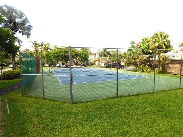 view of sport court with a lawn