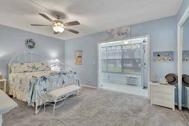 carpeted bedroom with an AC wall unit, a textured ceiling, and ceiling fan