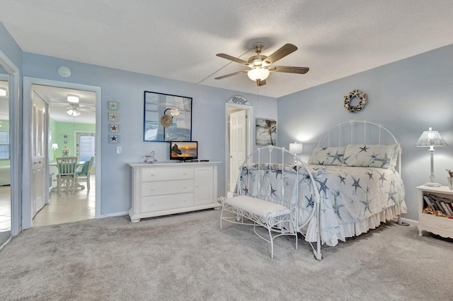 carpeted bedroom with a textured ceiling and ceiling fan