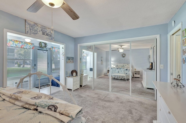 carpeted bedroom with a closet, a textured ceiling, ceiling fan, and cooling unit