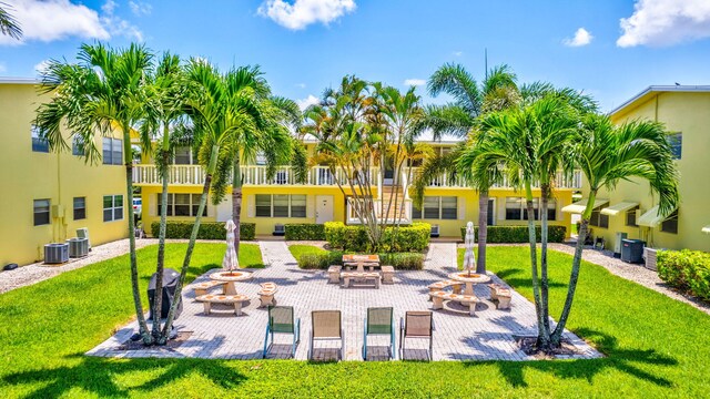 view of property's community featuring a patio, an outdoor fire pit, and a lawn