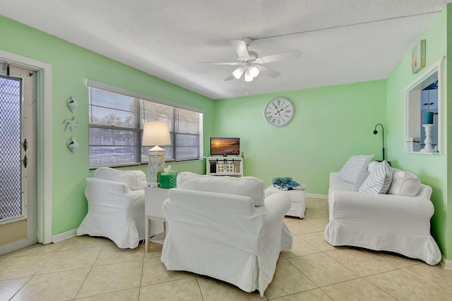 living room featuring light tile patterned flooring, a textured ceiling, and ceiling fan