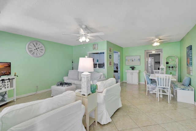 living room featuring a textured ceiling, ceiling fan, and light tile patterned floors