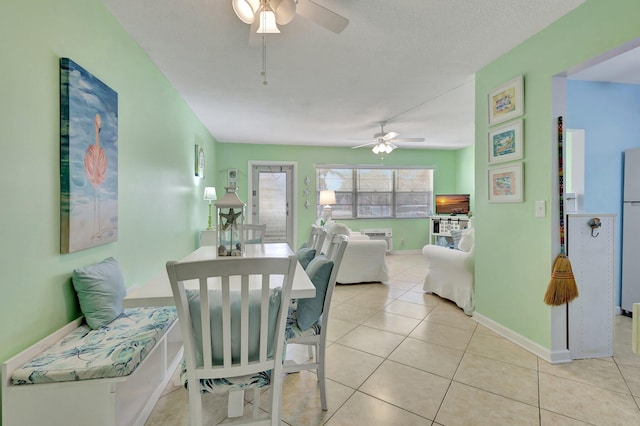 dining space featuring light tile patterned floors, a textured ceiling, and ceiling fan