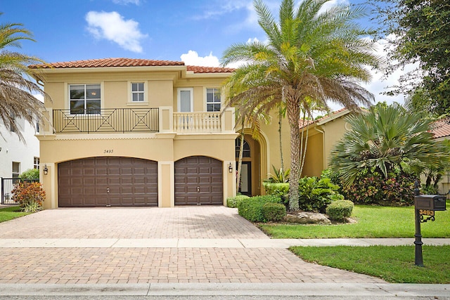 mediterranean / spanish home featuring a balcony and a garage