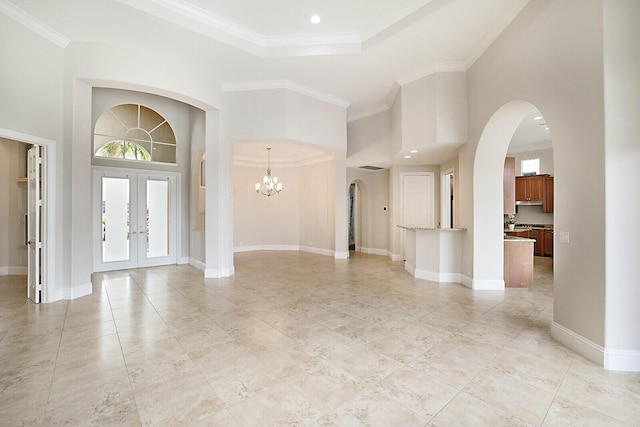 entryway featuring french doors, a high ceiling, and crown molding