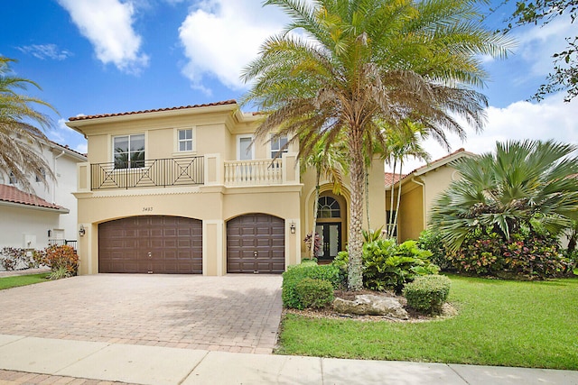 mediterranean / spanish house with a balcony, a garage, and a front lawn