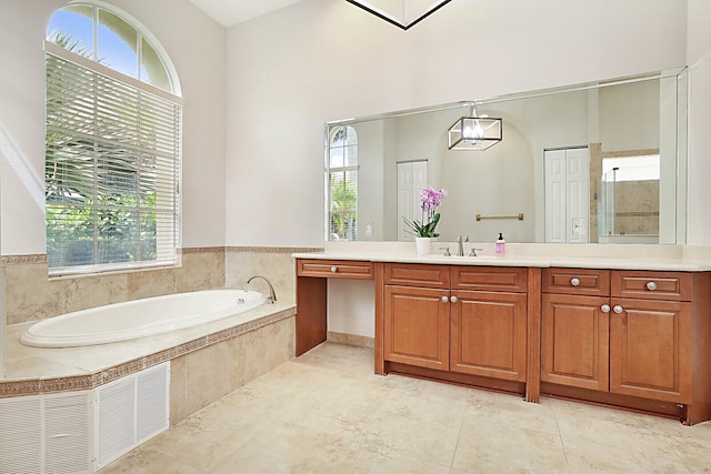 bathroom featuring a relaxing tiled tub and vanity