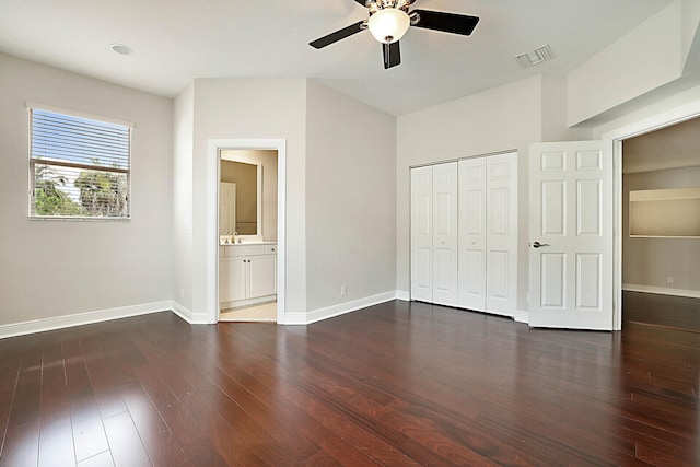 unfurnished bedroom with a closet, ceiling fan, dark hardwood / wood-style floors, and ensuite bath