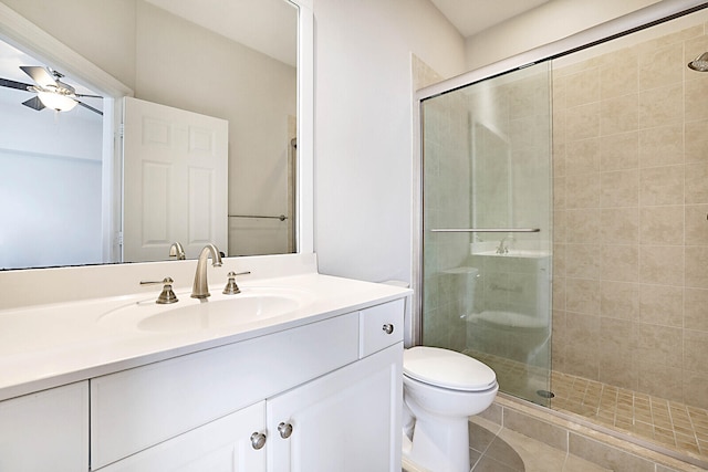 bathroom featuring toilet, tile patterned flooring, vanity, ceiling fan, and a shower with door