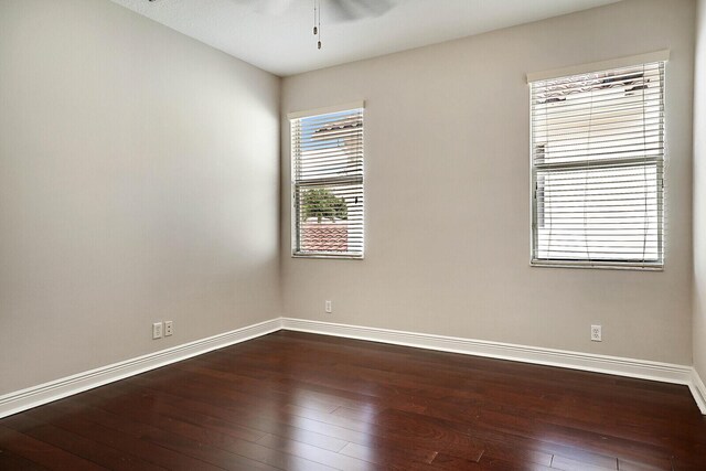 spare room featuring ceiling fan and dark wood-type flooring