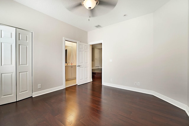 unfurnished bedroom featuring ceiling fan, dark wood-type flooring, and a closet