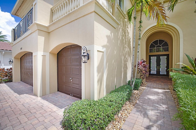 property entrance featuring a balcony and french doors