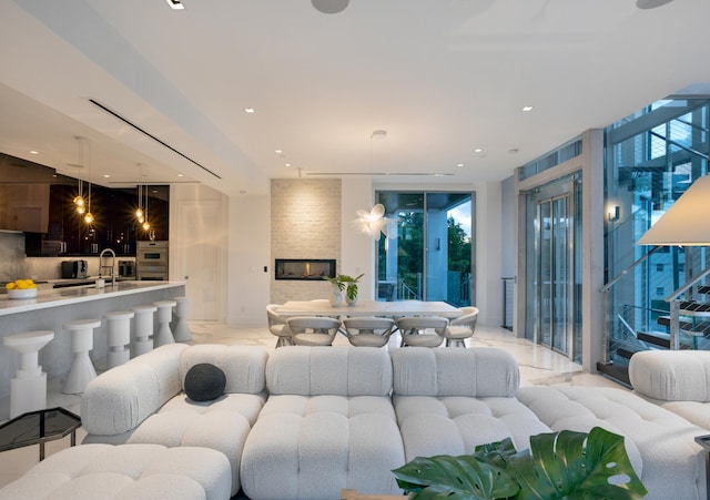 living room featuring floor to ceiling windows, sink, and a healthy amount of sunlight