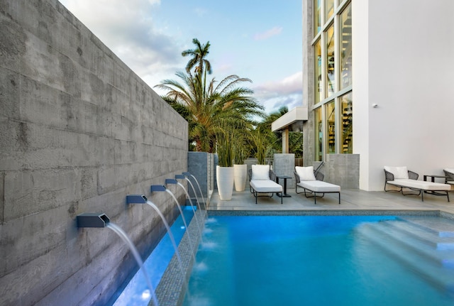 view of swimming pool with a patio and pool water feature