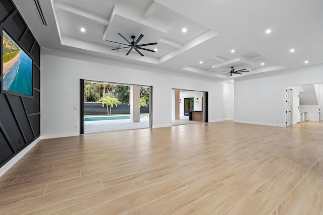 unfurnished living room with ceiling fan, coffered ceiling, and light wood-type flooring