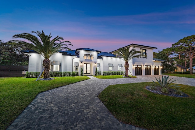 view of front of house featuring a lawn and french doors