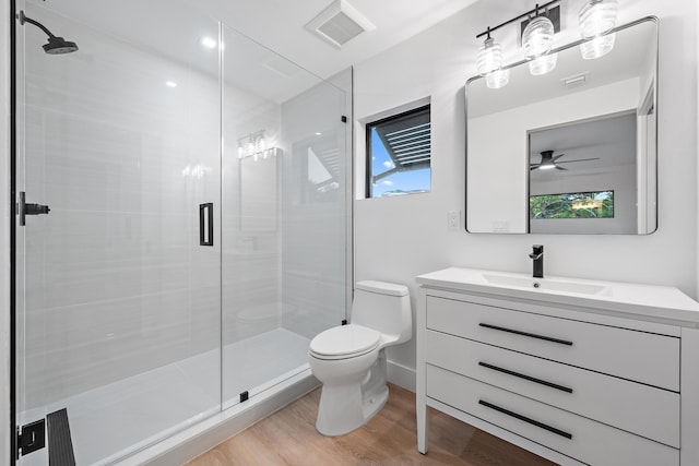 bathroom featuring hardwood / wood-style flooring, toilet, a wealth of natural light, and ceiling fan