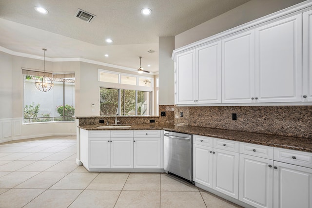 kitchen featuring dark stone countertops, dishwasher, sink, and white cabinets