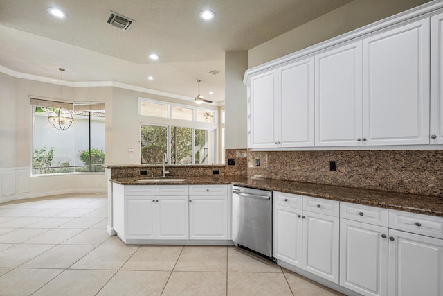 kitchen featuring dark stone counters, dishwasher, sink, and white cabinets