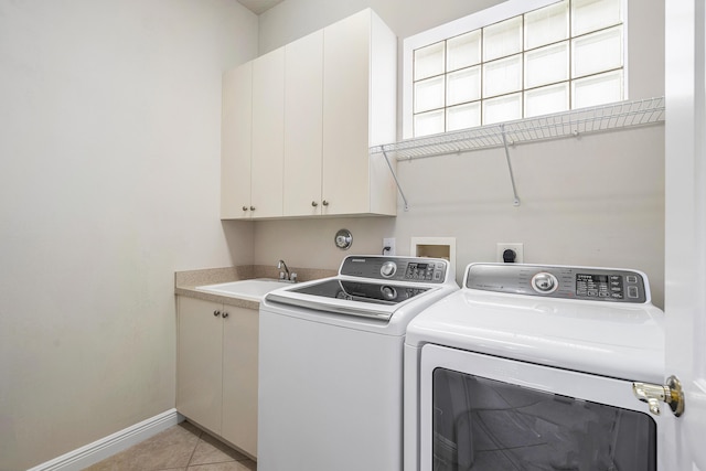 laundry area featuring cabinets, separate washer and dryer, sink, and light tile patterned floors