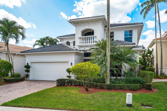 mediterranean / spanish house featuring a garage and a front yard