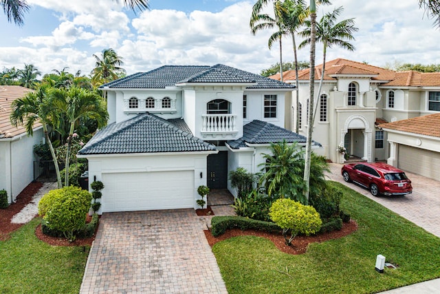 mediterranean / spanish-style home featuring a balcony, a garage, and a front lawn