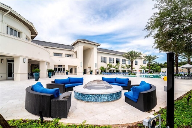 view of patio featuring an outdoor living space with a fire pit