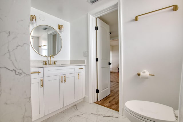 bathroom featuring vanity, toilet, and hardwood / wood-style flooring