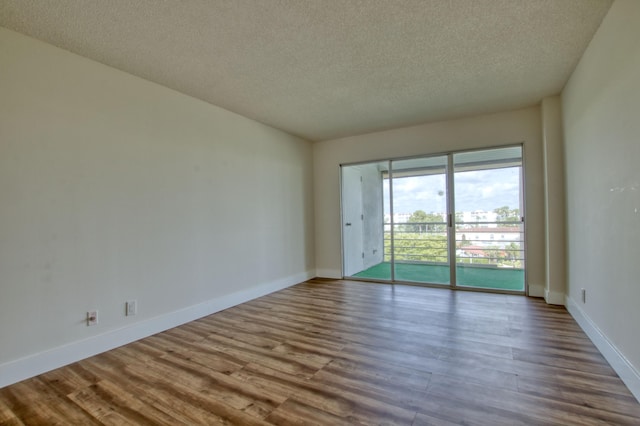 spare room with wood-type flooring and a textured ceiling